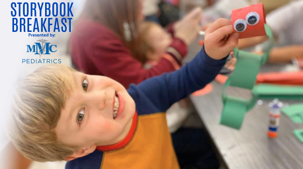 A child holding up a craft that was completed at Storybook Breakfast. 